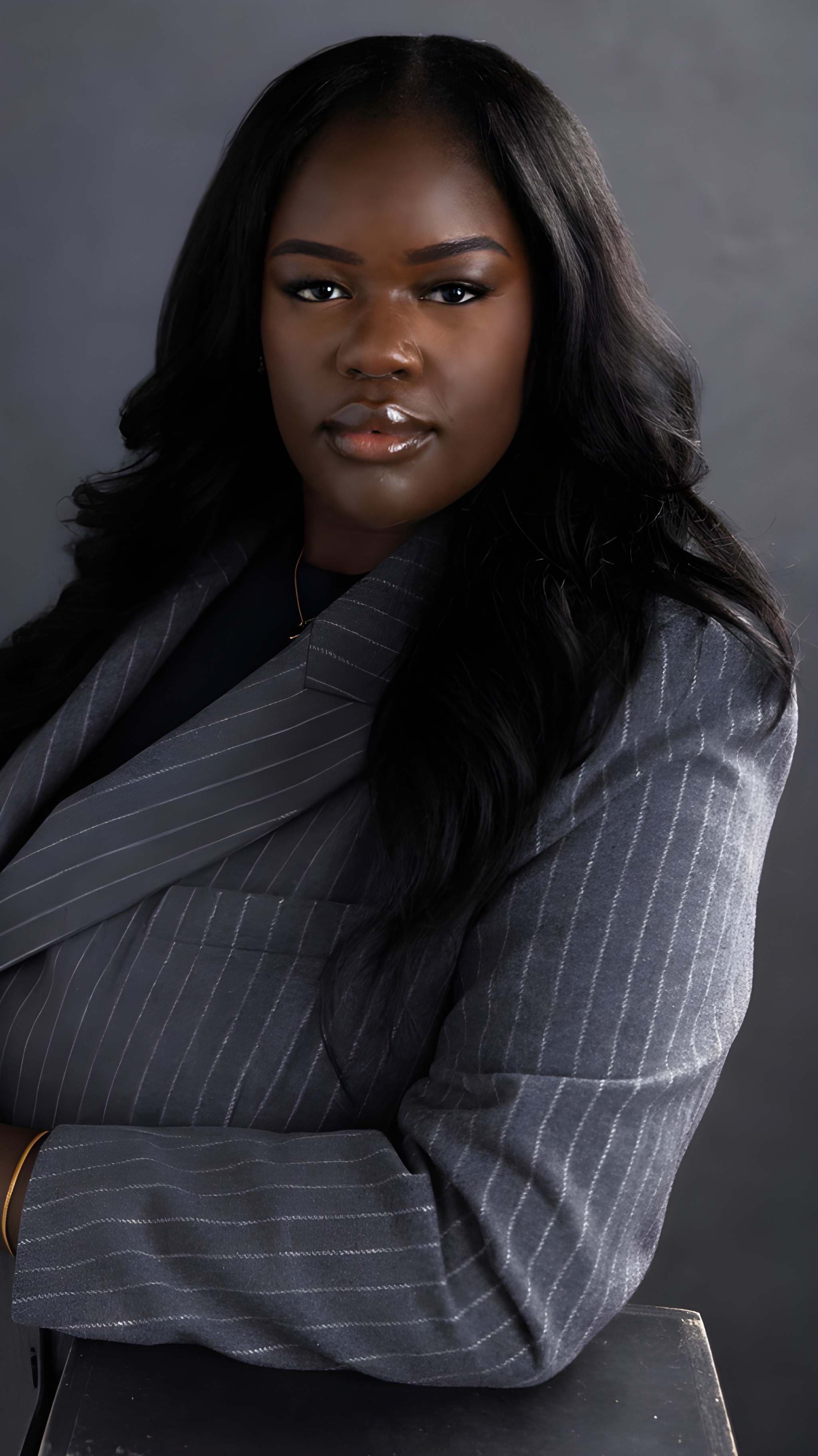 Joy Osinloye in a confident studio portrait with arms crossed