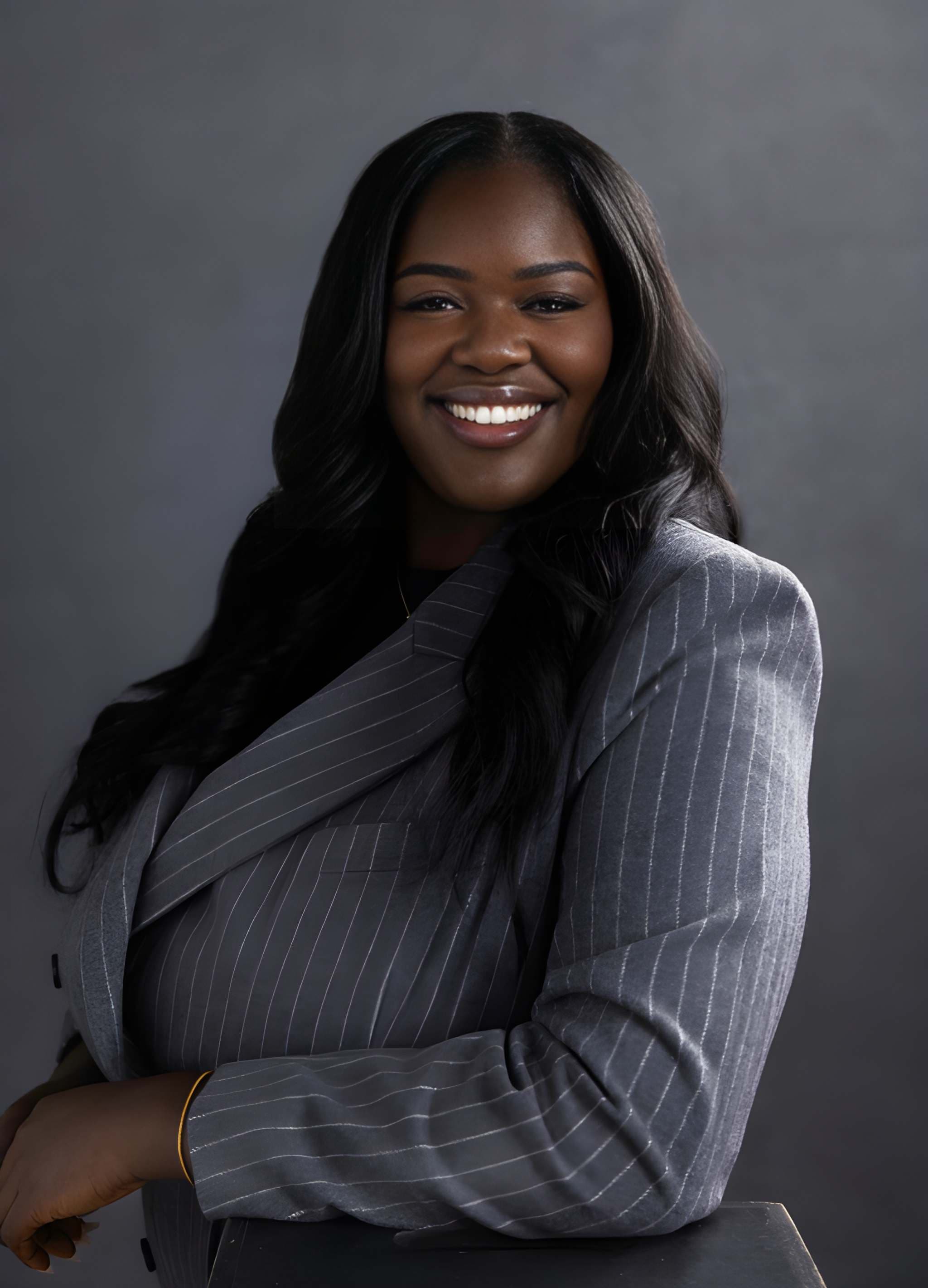 Joy Osinloye smiling in an executive studio portrait
