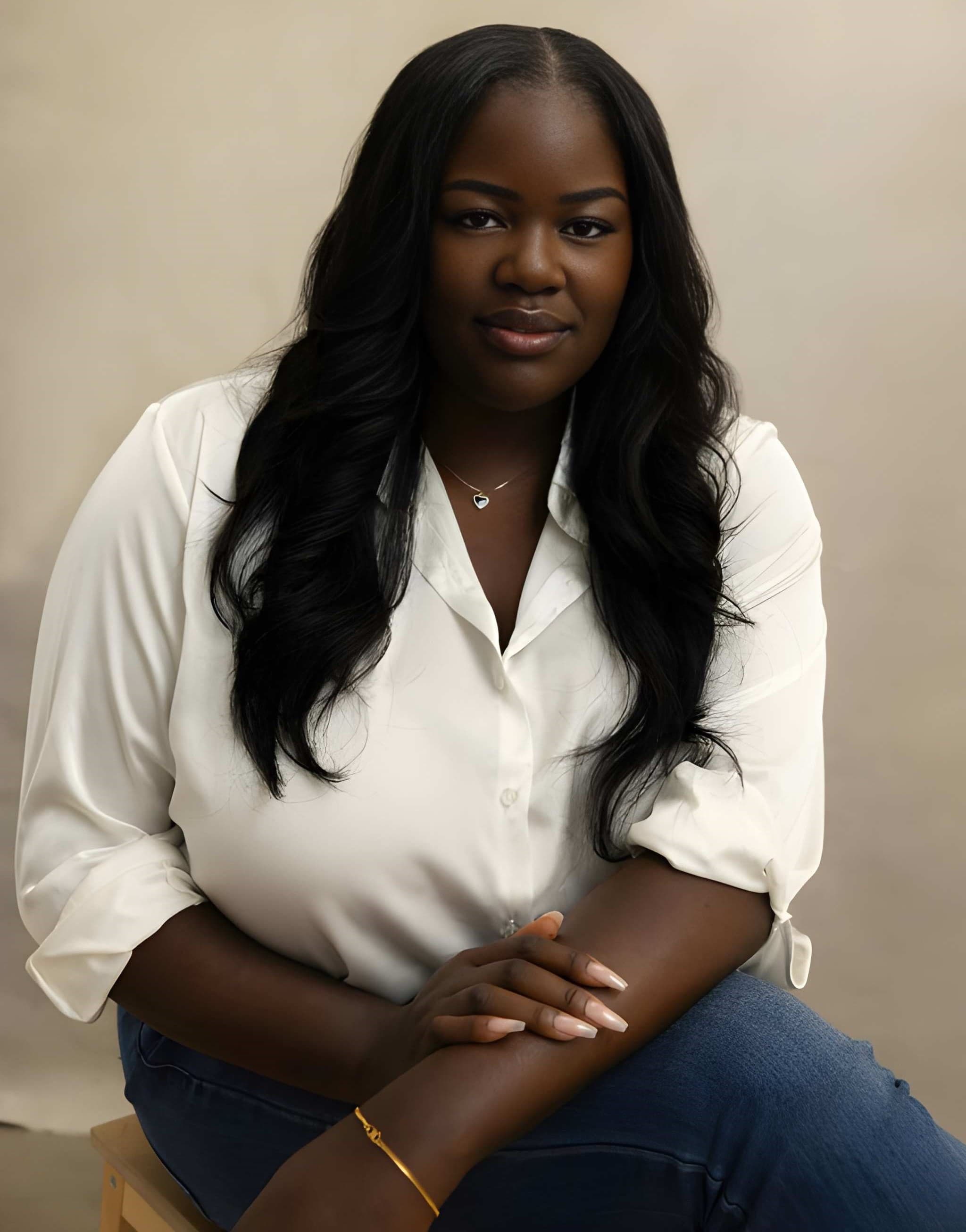 Joy Osinloye smiling warmly in a candid seated portrait